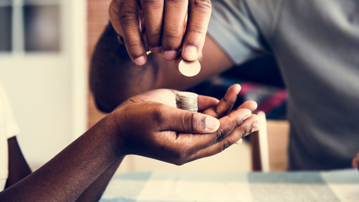 Dad giving coins to his daughter.