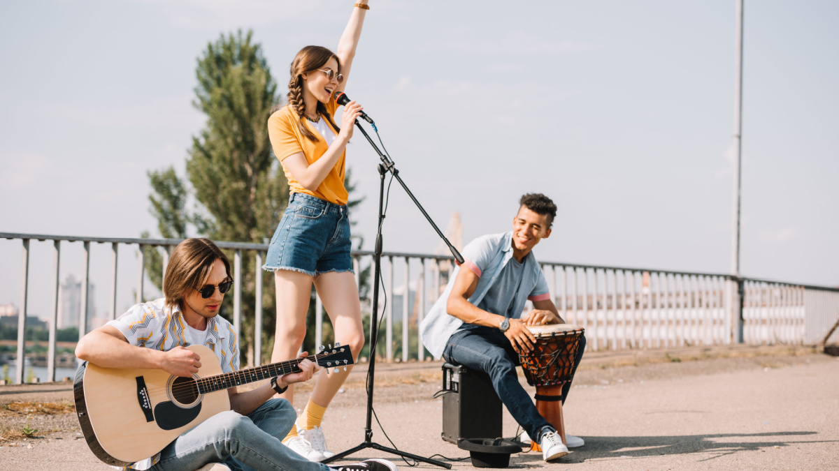 Multiracial young people performing singing on street?