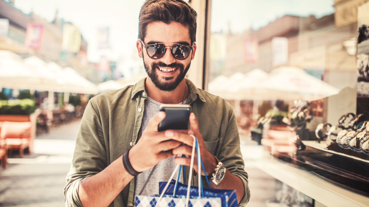 Smiling man enjoying in shopping. Consumerism, lifestyle concept.