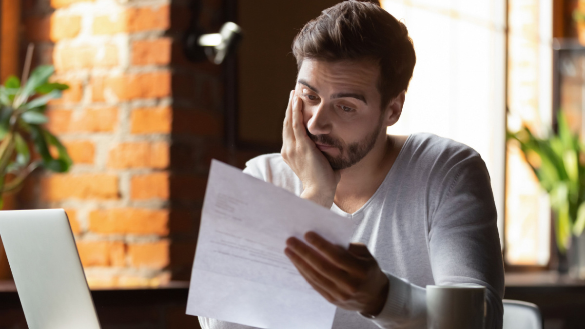 Confused frustrated young man reading letter in cafe, debt notification, bad financial report, money problem, money problem, upset student receiving bad news, unsuccessful exam or test results.