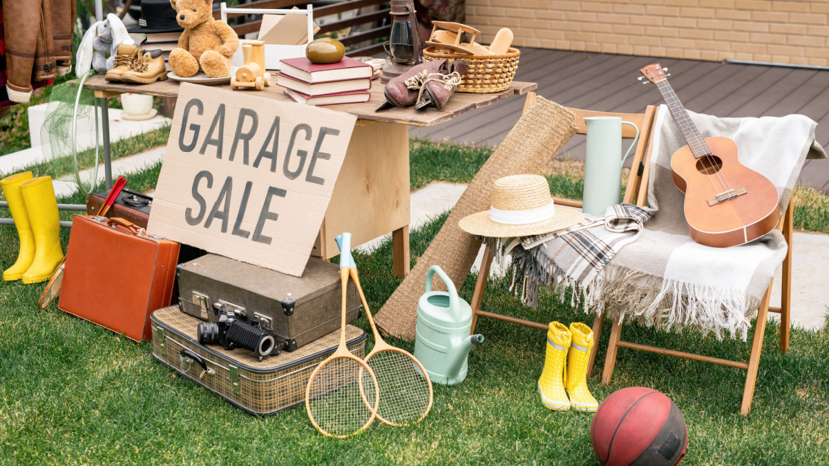 Various things placed on table and chairs in backyard, garage sale concept.