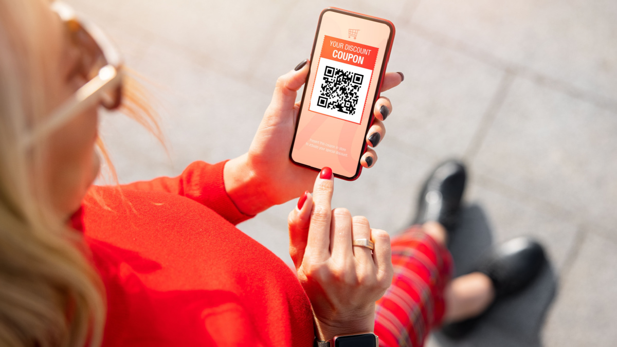 Woman viewing discount coupon on mobile phone.