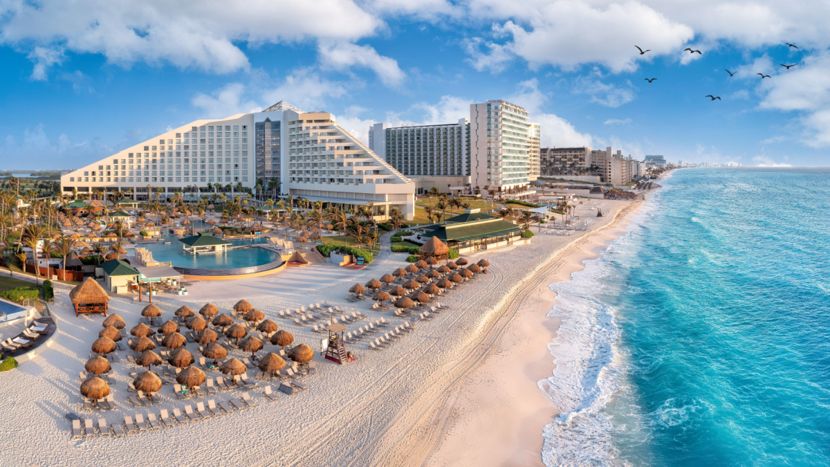 Cancun beach with resorts near blue ocean.