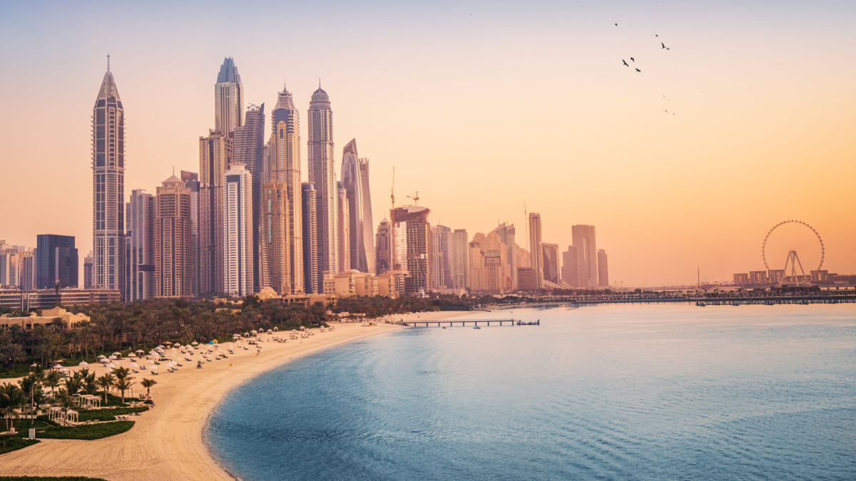Sunset view of the Dubai Marina and JBR area and the famous Ferris Wheel and golden sand beaches in the Persian Gulf. Holidays and vacations in the UAE.