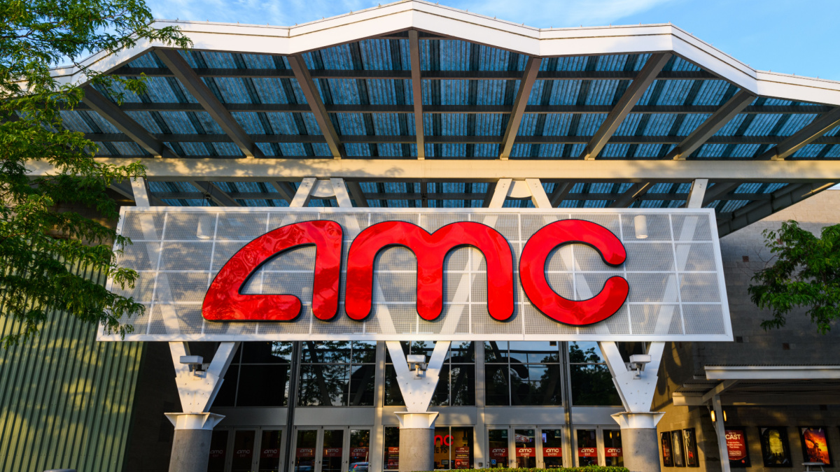 Woodinville, WA, USA - June 07, 2021; AMC movie theater front glowing in the setting sun with the name shining bright red. This company traded wildly on the NYSE in June 2021 after reopening.