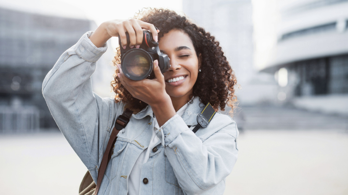 Woman photographer with dslr camera taking pictures outdoor.