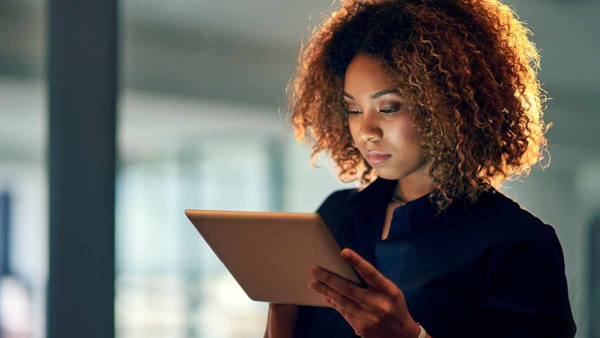 Working smart, working hard. Shot of a young businesswoman using a digital tablet during a late night at work.