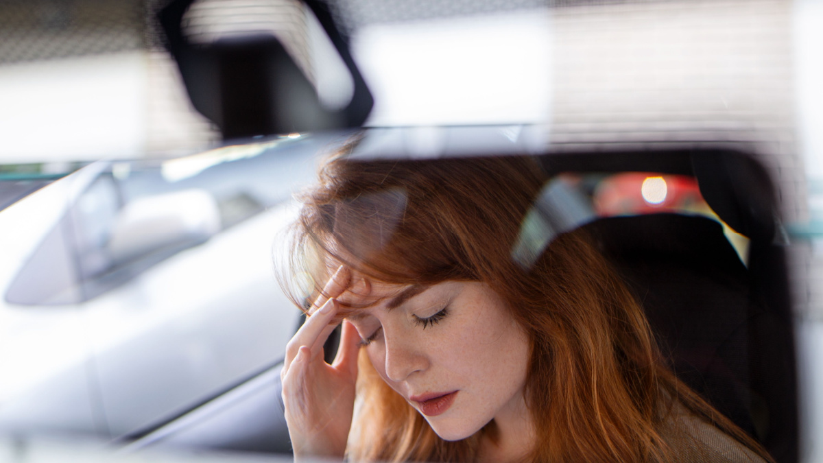 Beautiful upset woman sitting in automobile and crying, break-up and sadness.