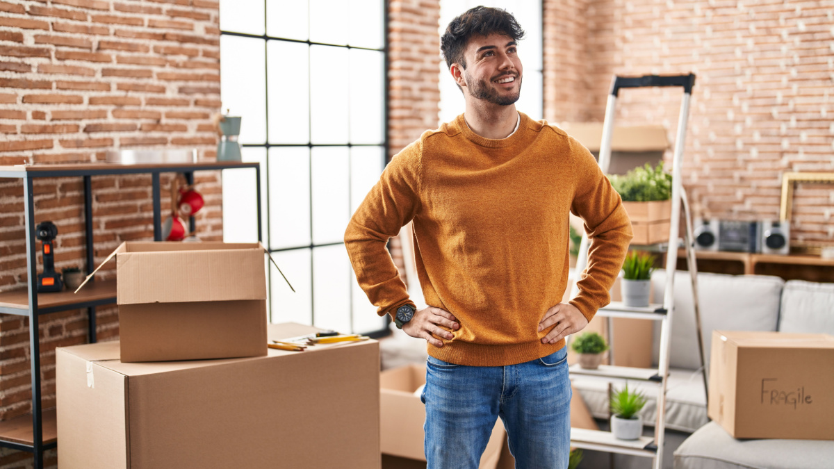 Young hispanic man smiling confident standing at new home.