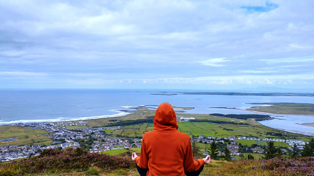 Man meditating yoga at mountains. Medidations on the moutain cliff.