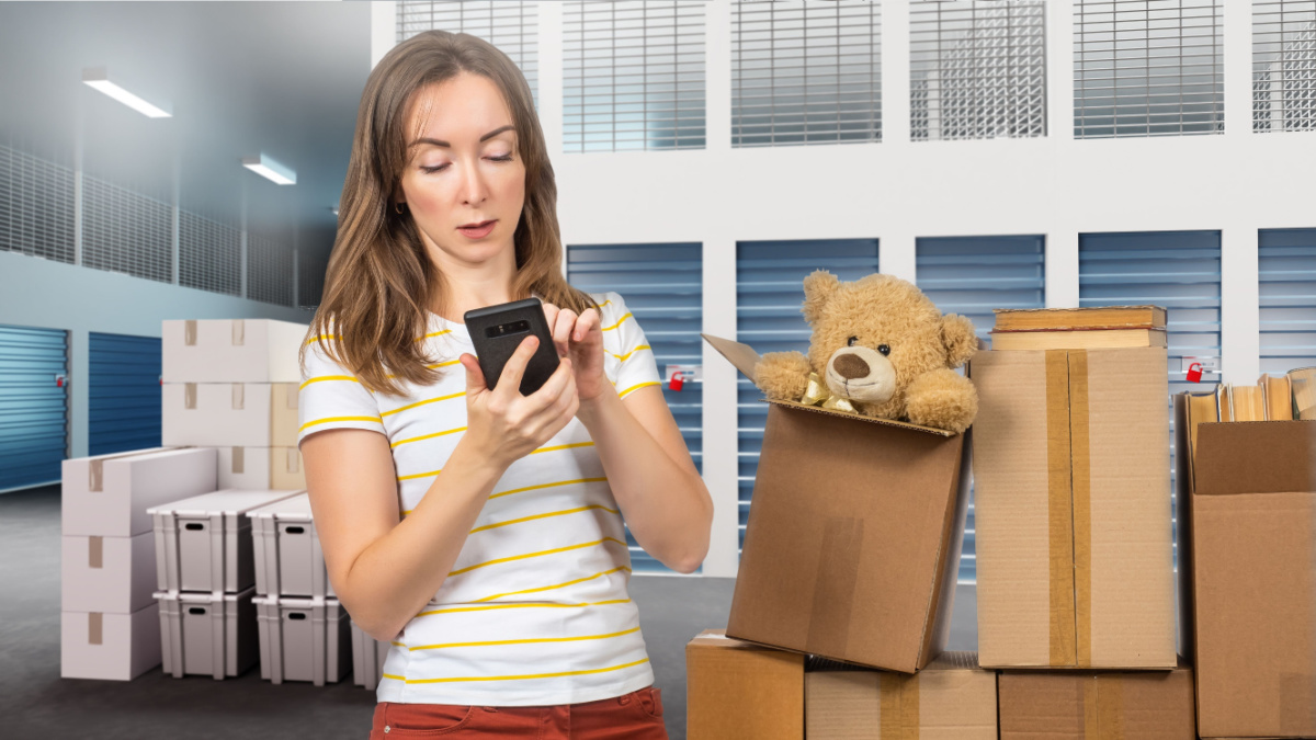 Warehouse woman. Girl rents cell for storage. Boxes with personal belongings near female.