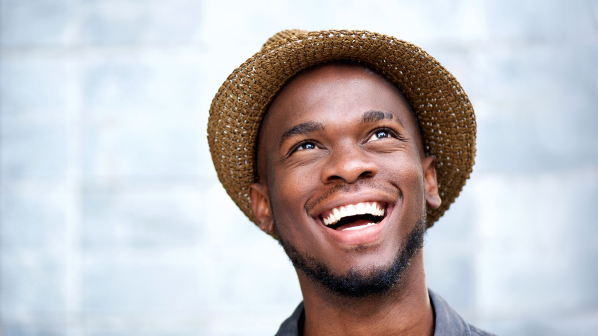 Close up portrait of a cheerful young man laughing and looking up.