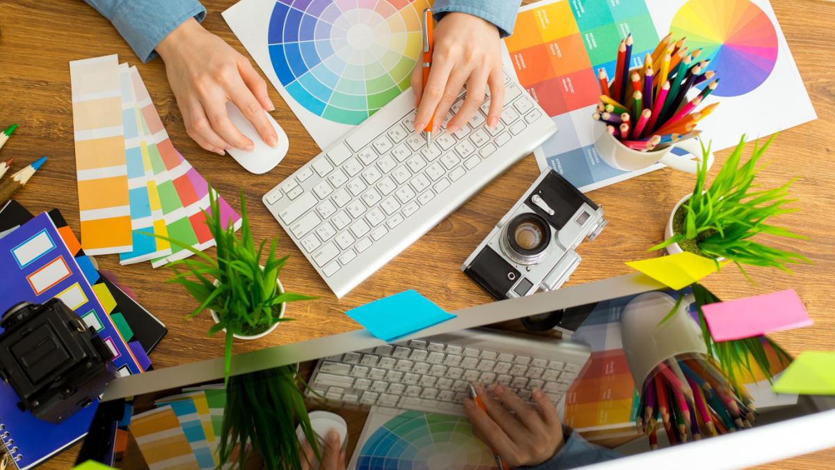 Young cute Graphic designer using graphics tablet to do his work at desk.