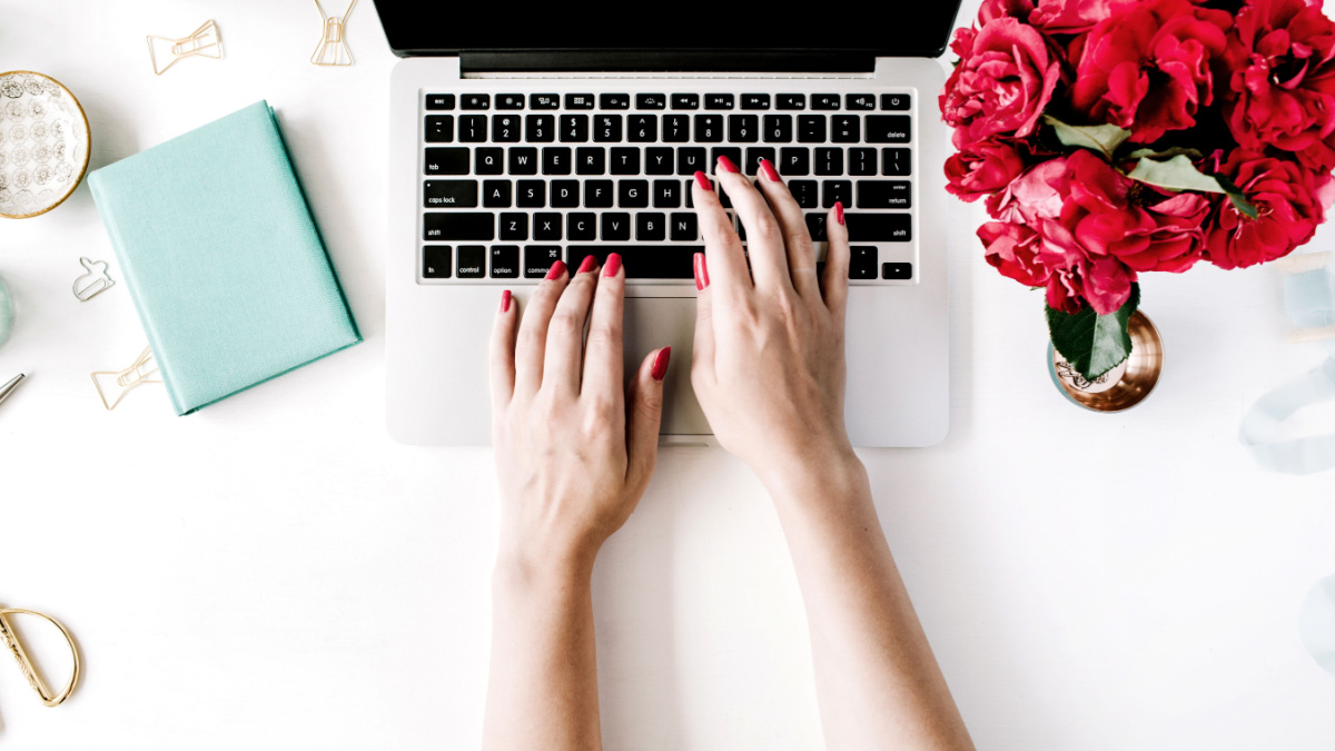Workplace with laptop, girl's hands, peonies, golden scissors and diary. Flat lay composition for bloggers, magazines, social media and artists. Top view.