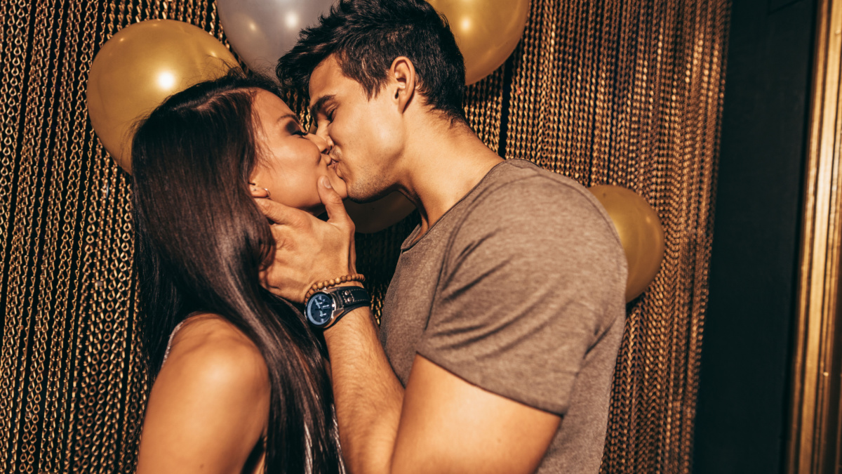 Shot of romantic young couple kissing in the night club.