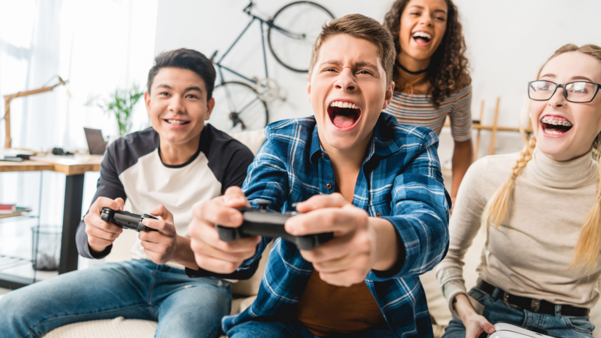 laughing multicultural teens playing video game.