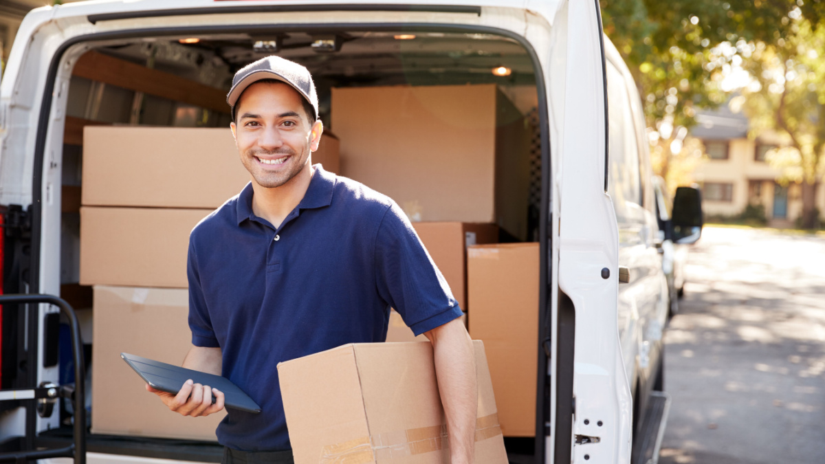 Portrait Of Courier With Digital Tablet Delivering Package.