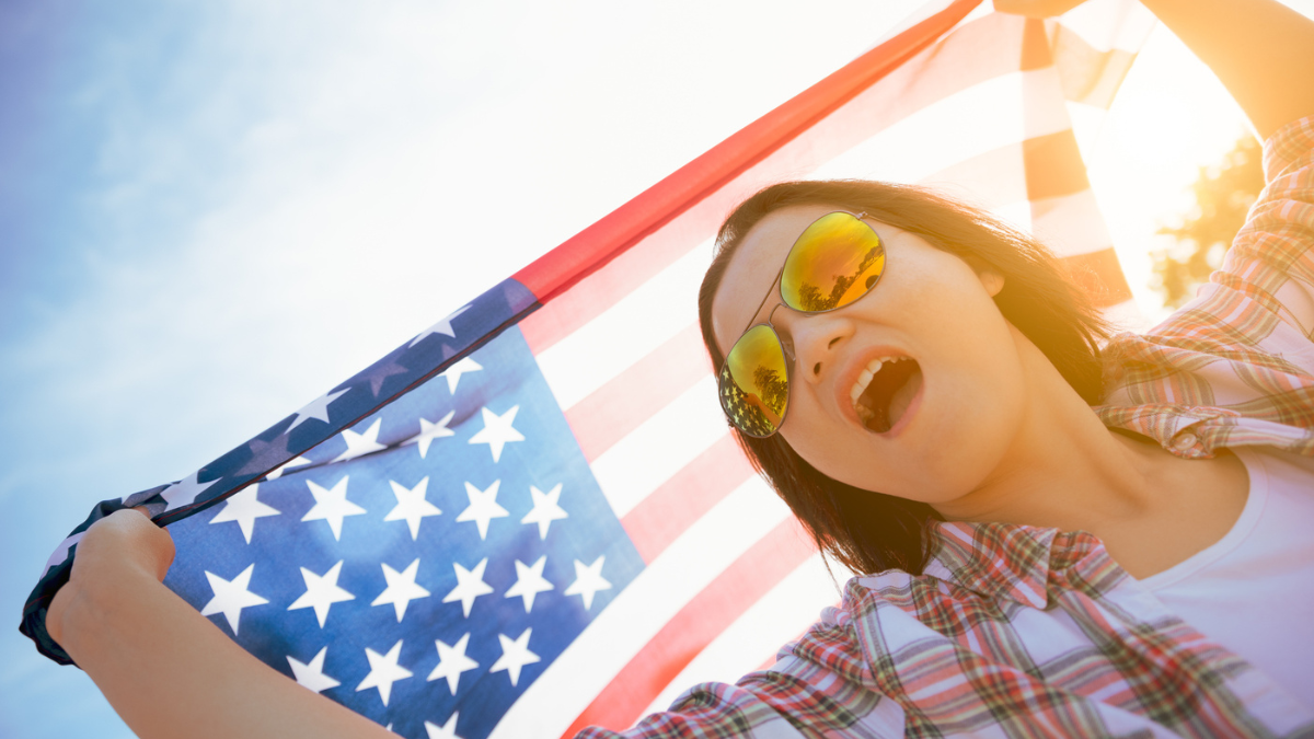 Close up happy woman holding United States of America flag.