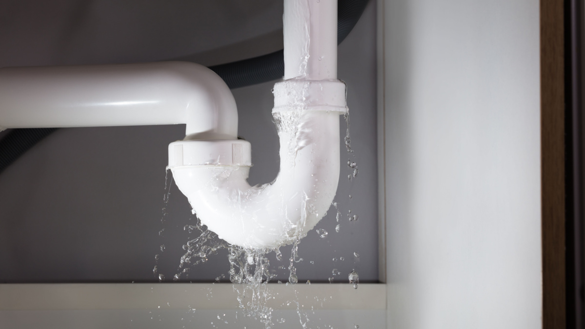 Close-up Of Water Is Leaking From The White Sink Pipe.