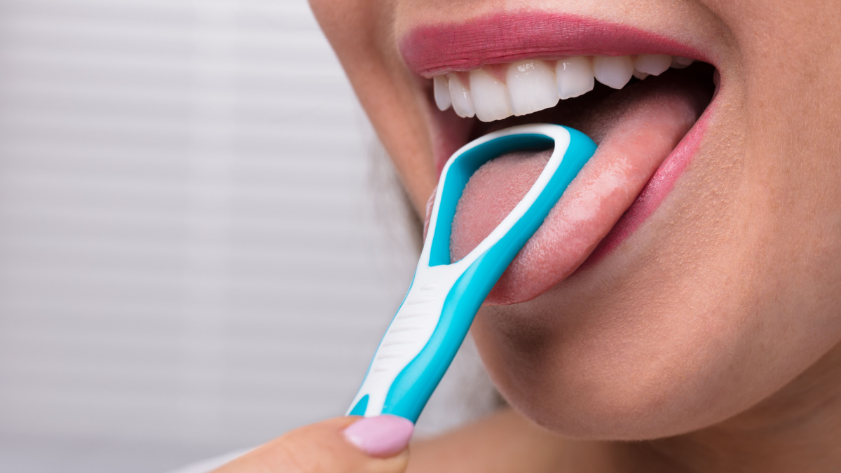 Close-up Of A Woman Cleaning Her Tongue With Cleaner