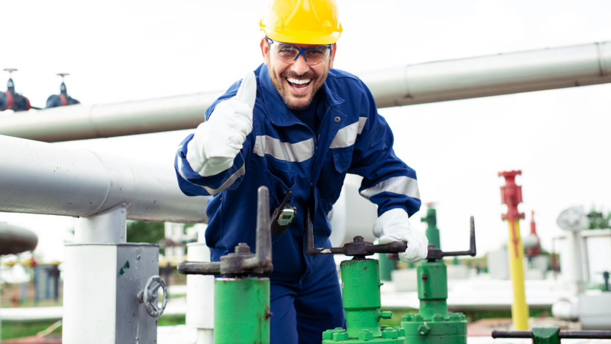 Worker closes the valve on the oil pipeline