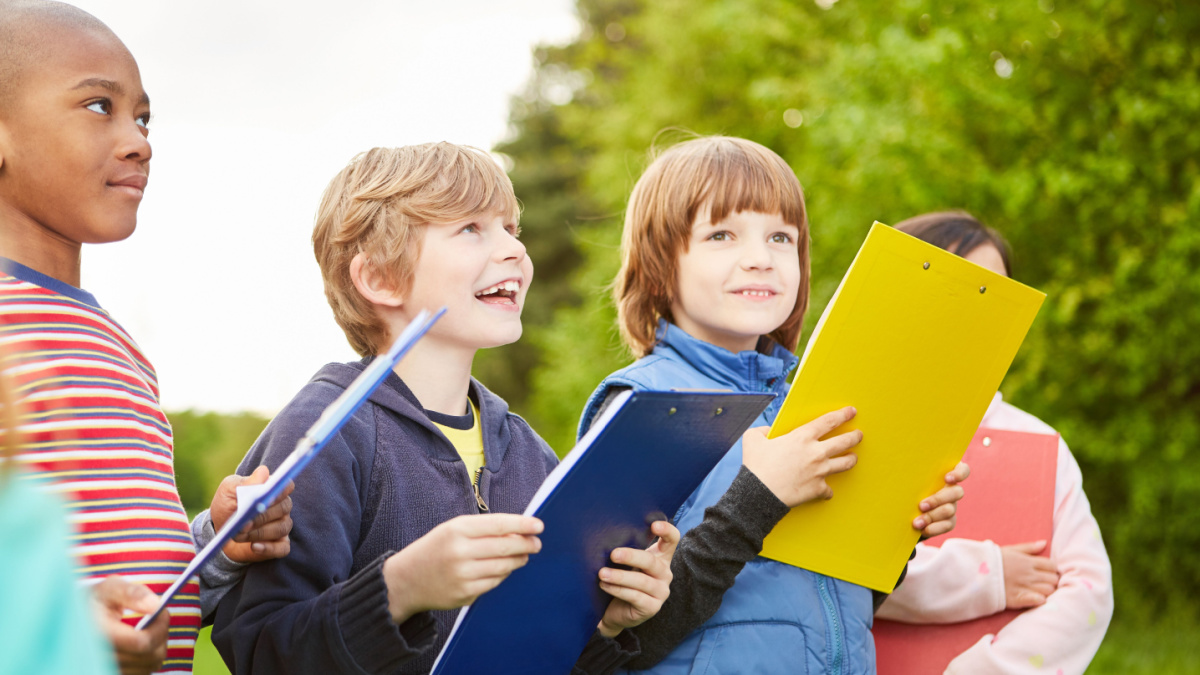 Group of kids together play scavenger hunt at kids birthday with clipboard