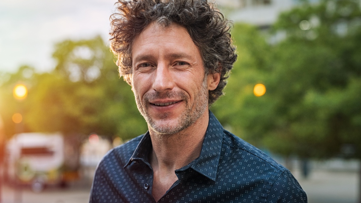 Portrait of happy mature man looking at camera outdoor.