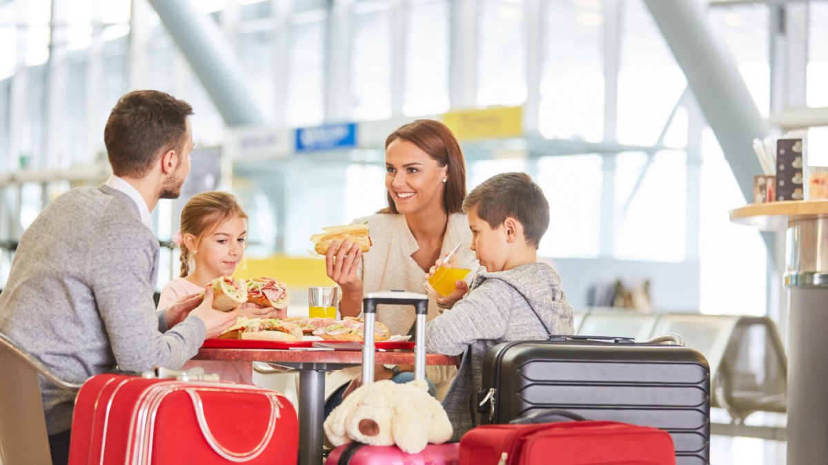 Family with children eating in restaurant before leaving airport or train station