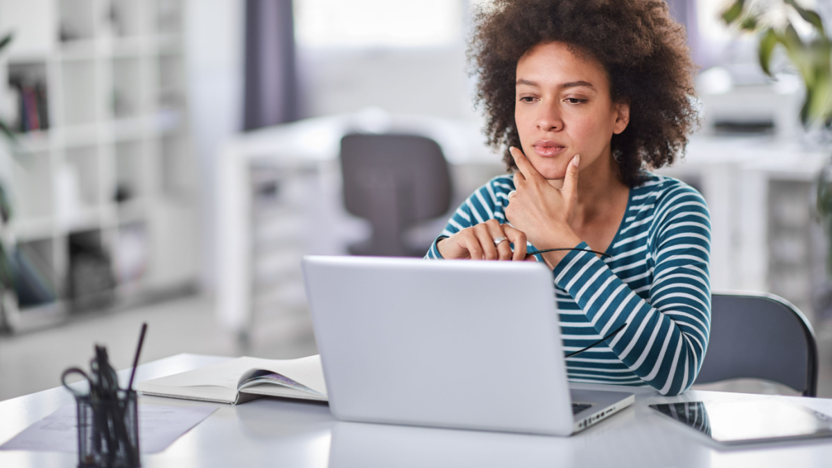 Cute mixed race businesswoman dressed casual thinking how to solve a problem while sitting in modern office.