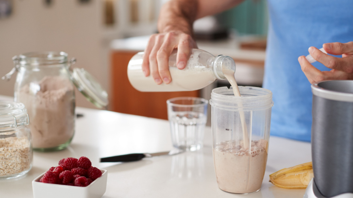 Close Up Of Man Making Protein Shake After Exercise At Home