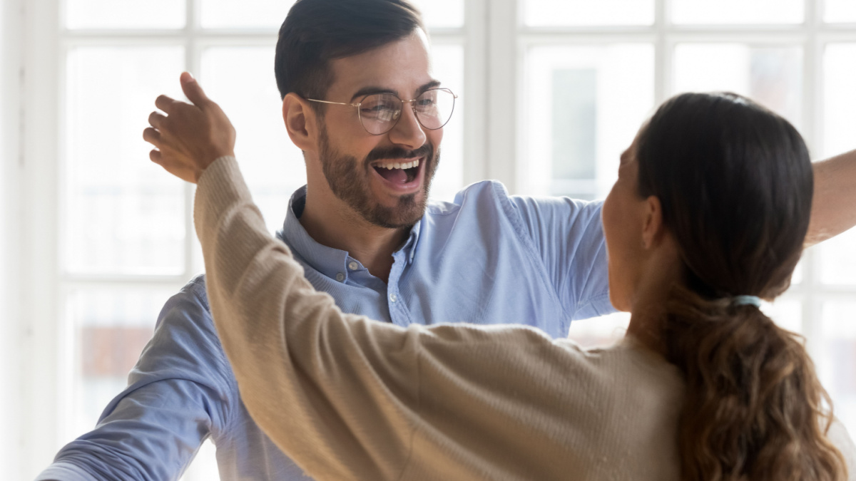 Excited young man in eyeglasses suddenly meeting mixed race female friend. Cheerful millennial best friends hugging cuddling embracing greeting each other, true strong trustful friendship concept.