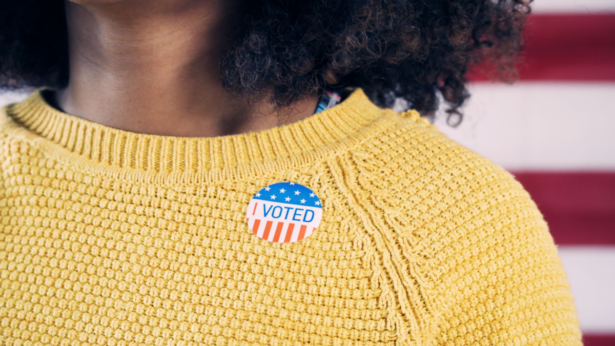 Young Gen Z Voter Wearing Sticker After Voting in Election.