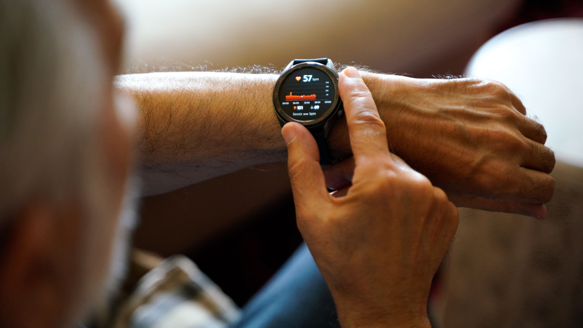 old white haired man using smart watch checking his cardiogram ecg.