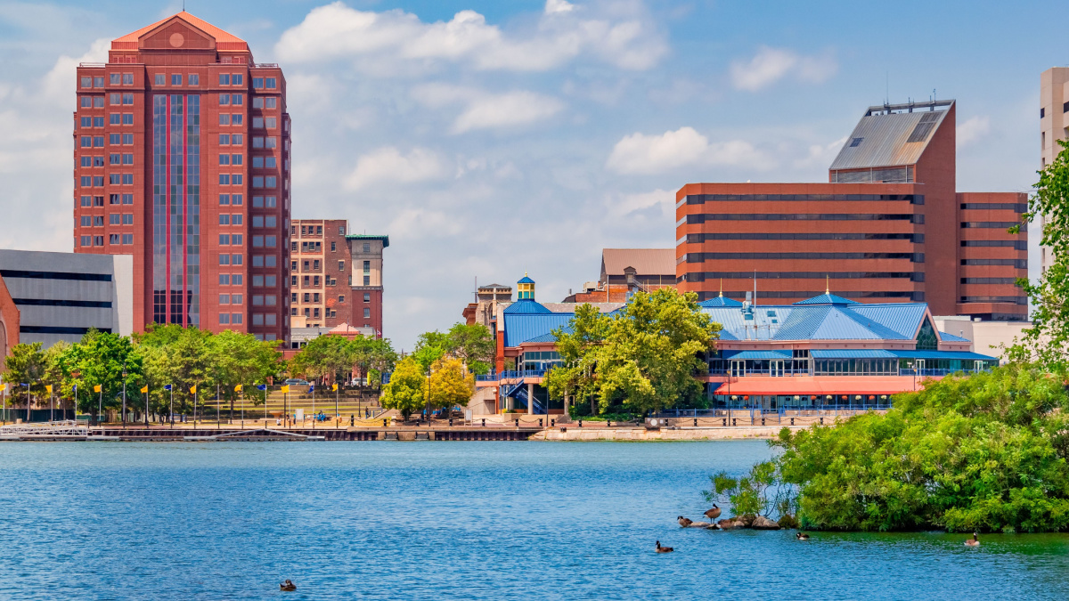 Downtown Toledo Ohio is filled with multi colored architecture that sits alongside the Maumee River. Ducks float in the water and sit on the island.