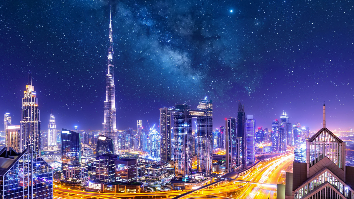 Amazing skyline cityscape with illuminated skyscrapers. Downtown of Dubai at night with stars and milky way, United Arab Emirates.