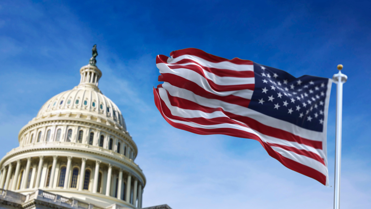 American flag waving with the US Capitol Hill in the background.