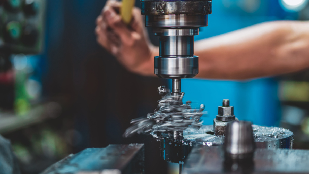 Professional machinist hand working with milling machine in metalworking factory, lathe metalworking industry concept