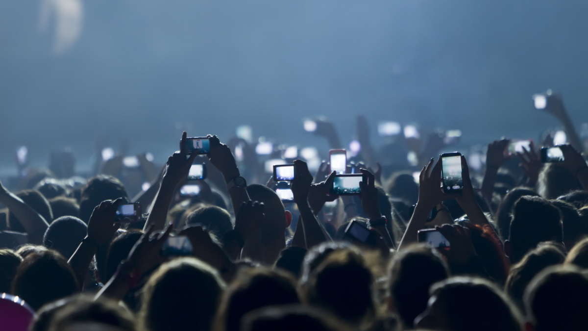 People taking photographs with touch smart phone during a music concert live on stage for the Ace of Heart tour at Sports arena in Thessaloniki.