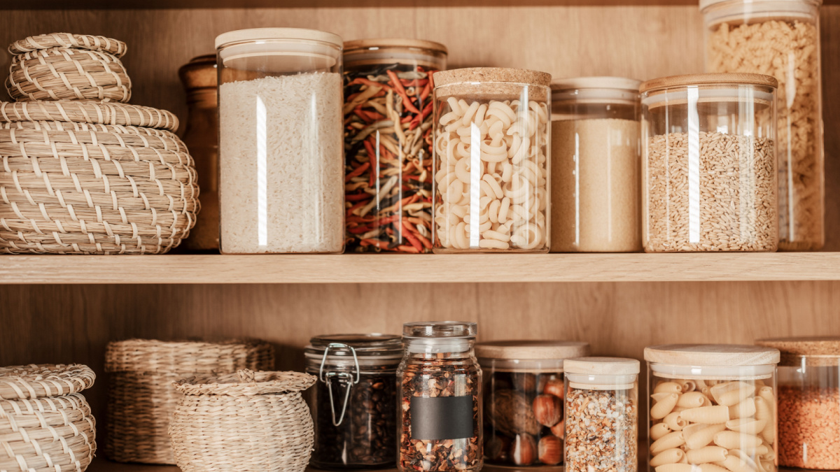 Organizing zero waste storage in kitchen. Pasta and cereals in reusable glass containers in kitchen shelf