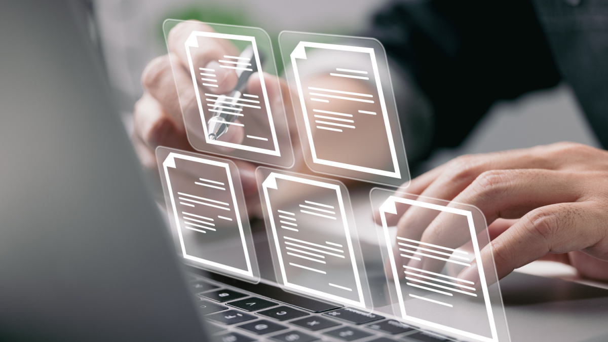 Businessman working on laptop computer with electronics document icons, E-document management, online documentation database, paperless office concept.