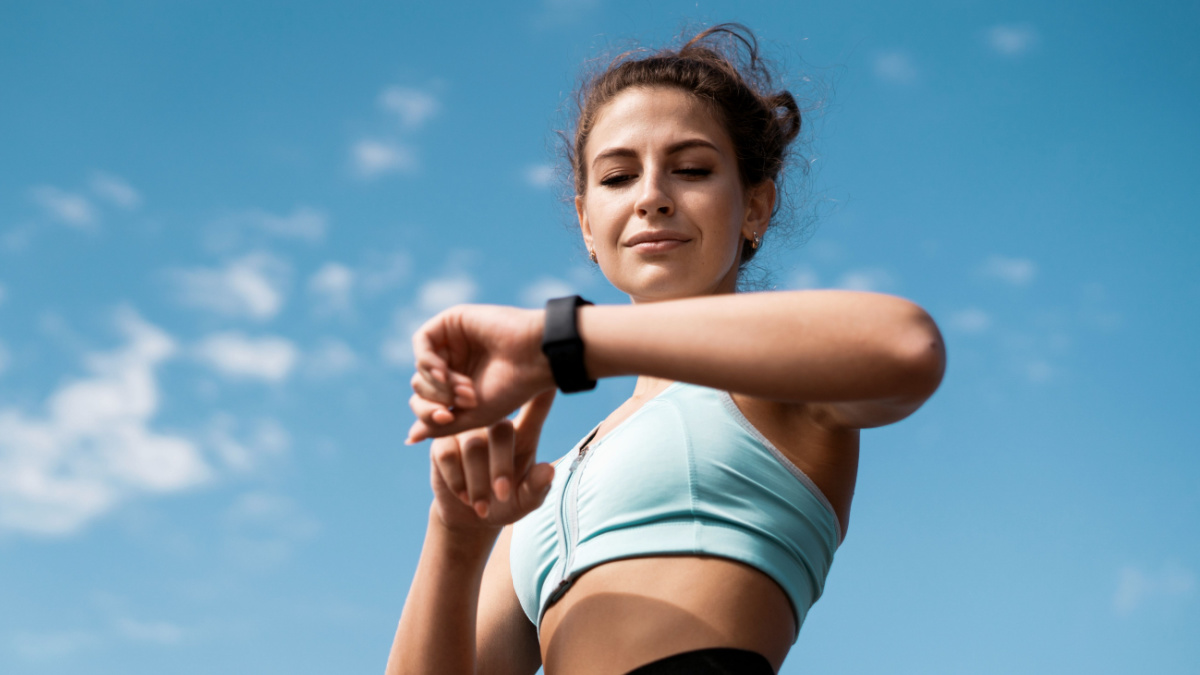 20 Essential Habits for a Longer, Healthier Life 3 The athlete watches cardio, fitness in the city. A woman looks at sports and counts calories during training.