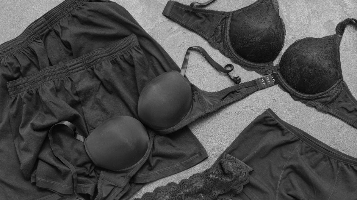 Stylish female and male underwear on grey background