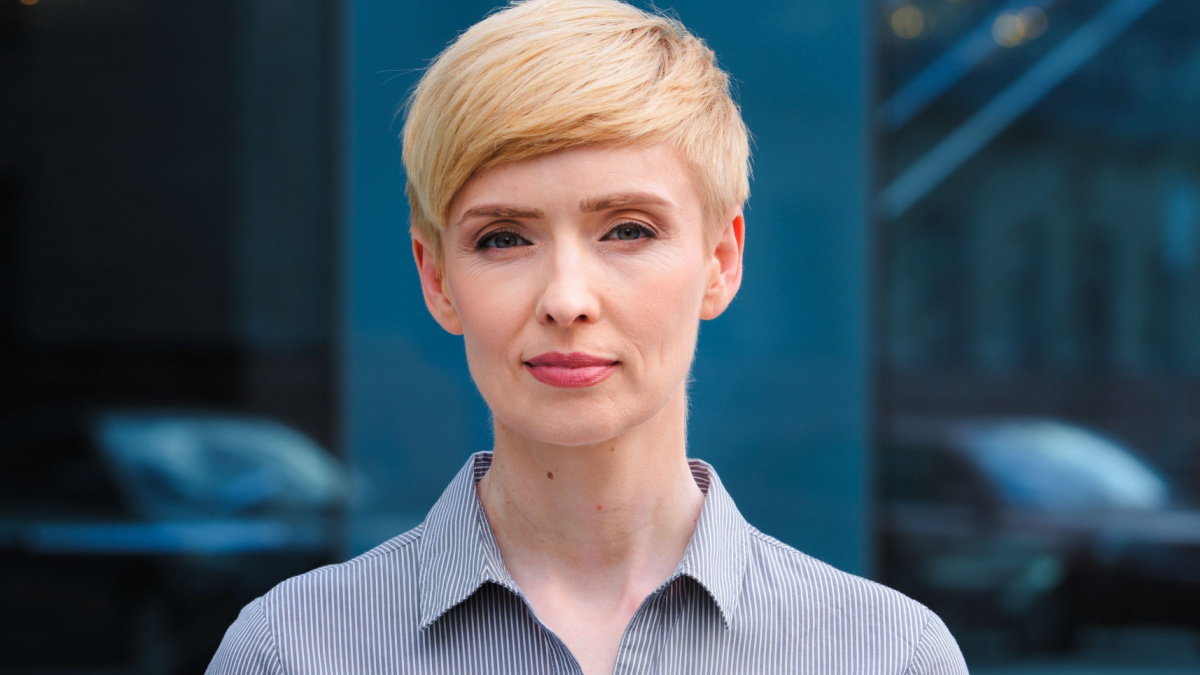 Close-up female serious face headshot portrait outdoors caucasian middle aged business woman boss blonde short haired lady wears formal shirt unhappy calm looking at camera standing posing on.