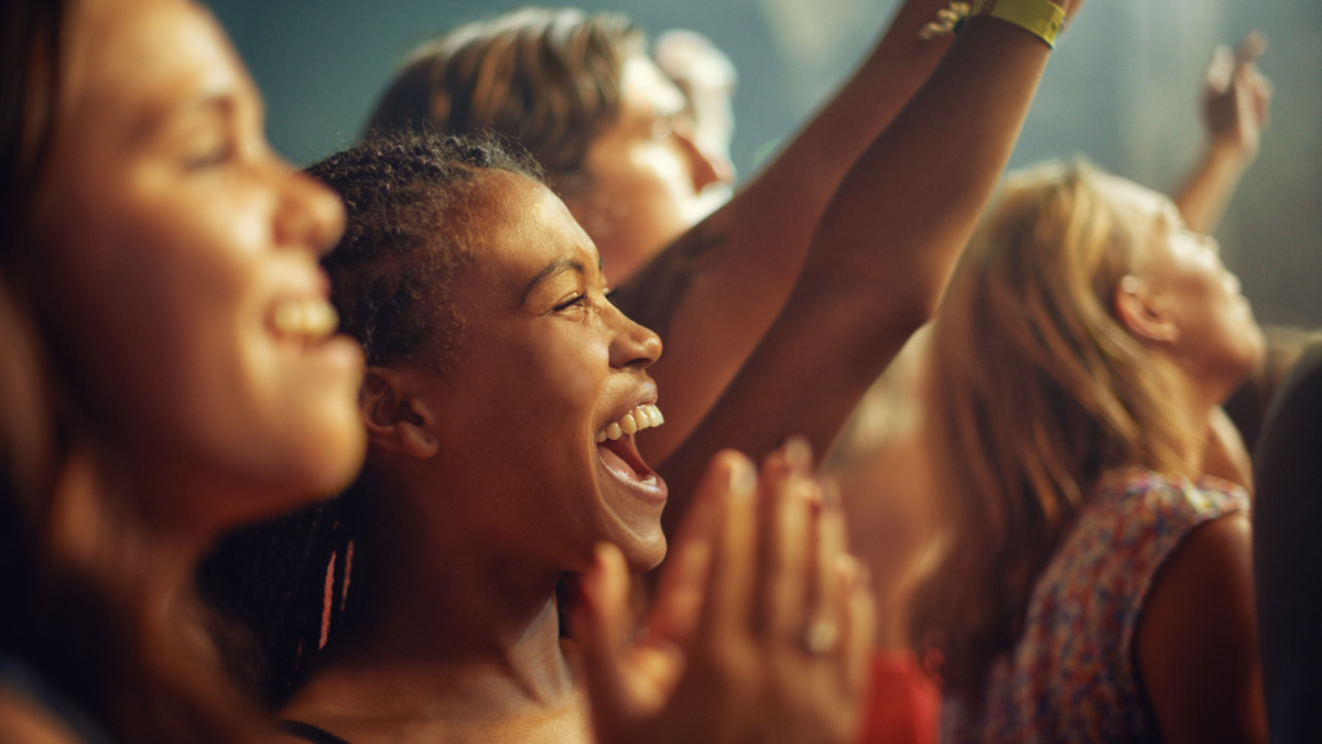 Having the time of their lives. Young girls in an audience enjoying their favorite bands performance.