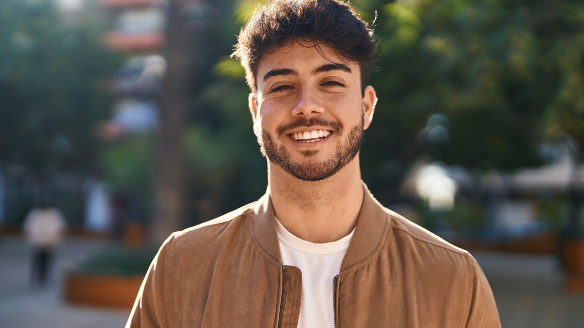Young hispanic man smiling confident standing at park.