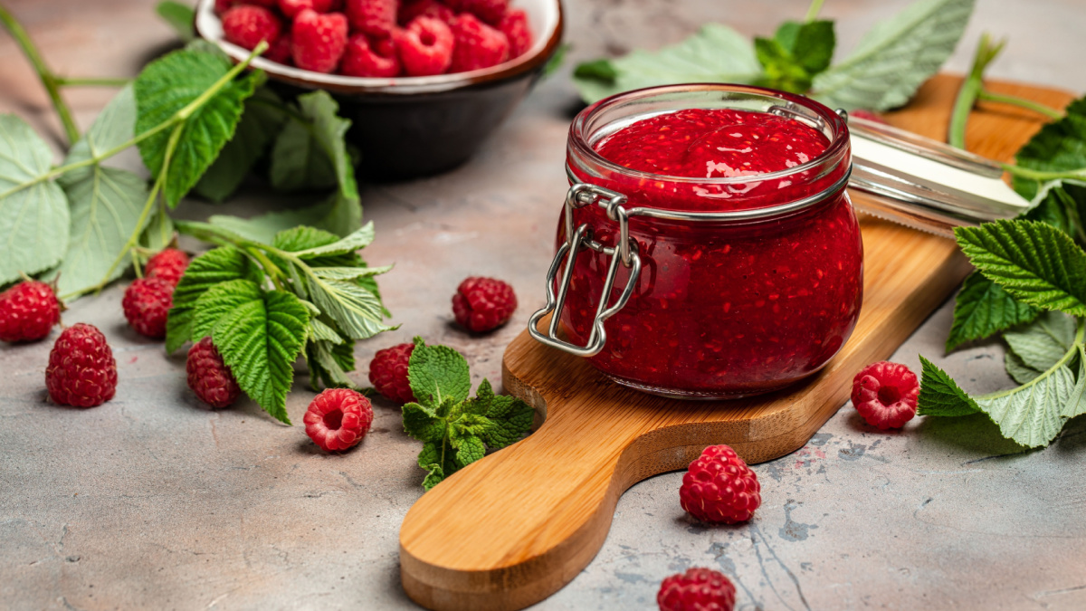 Raspberry jam with berry on light background. Homemade jam with raspberry.
