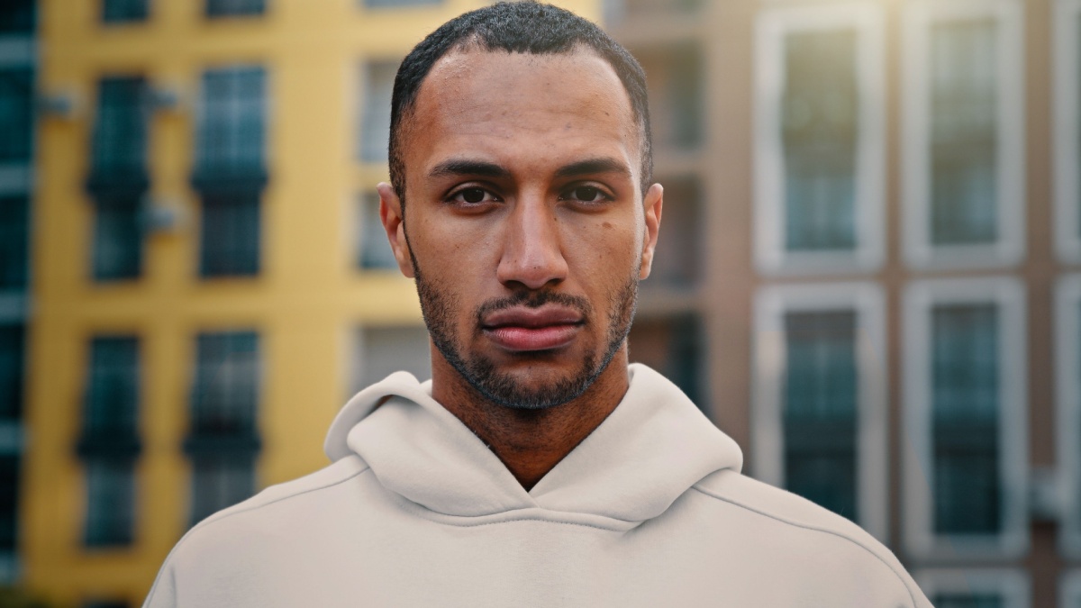 American latino man handsome male athletic muscular guy serious looking at camera stand on city street nodding head supporting idea approval gesture agree consent accepting healthy sportive lifestyle.