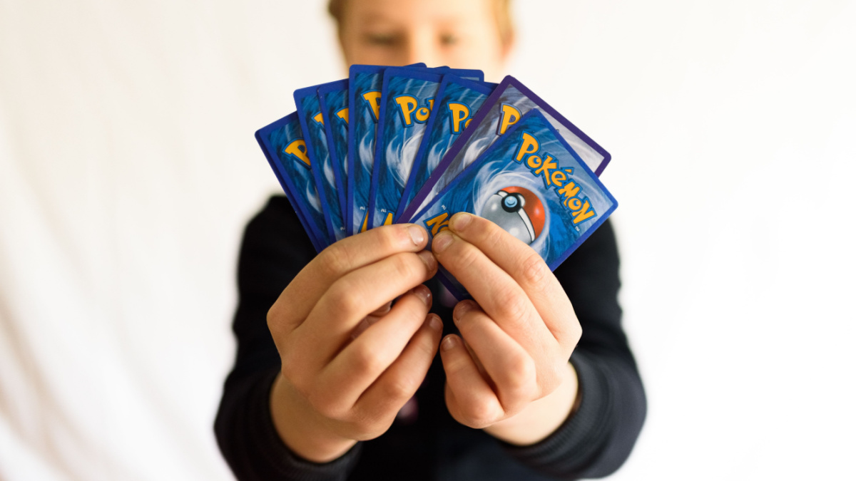 Valencia, Spain - January 10, 2023: A single boy male hand holds a pokemon trading card game.
