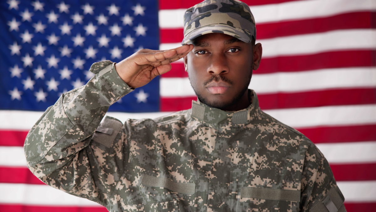 Rear View Of Military Man Saluting Us Flag.