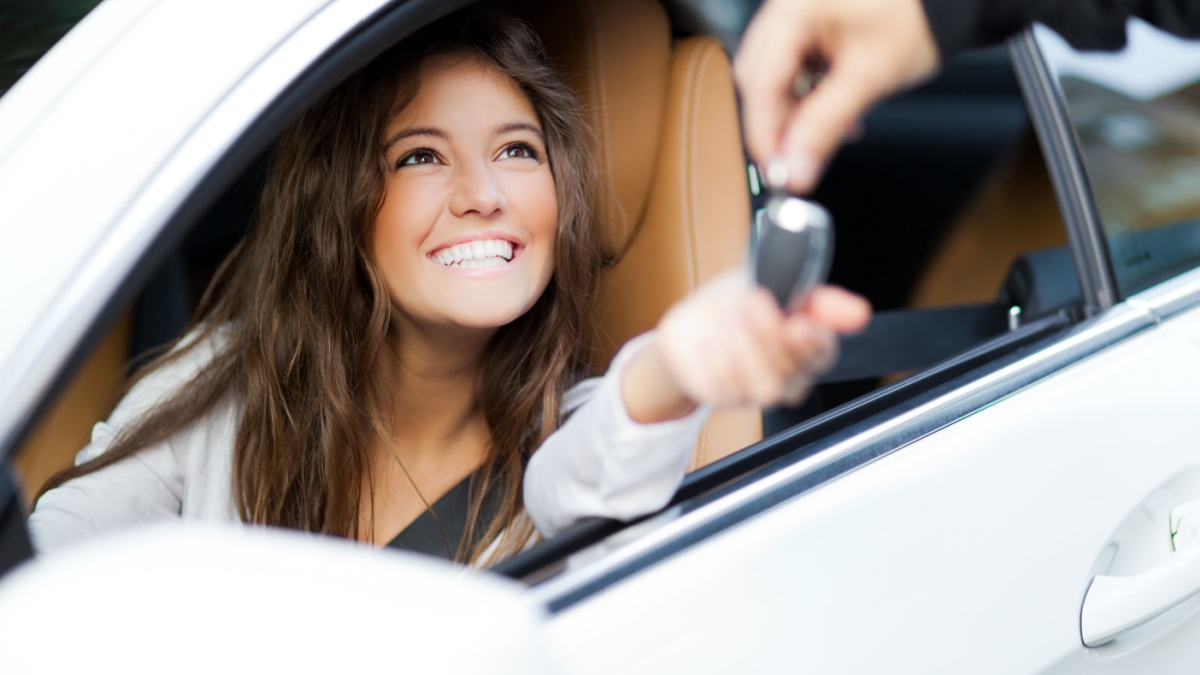 12 Reasons You Should Never Buy a Car in Cash 9 Young woman receiving the keys of her new car.
